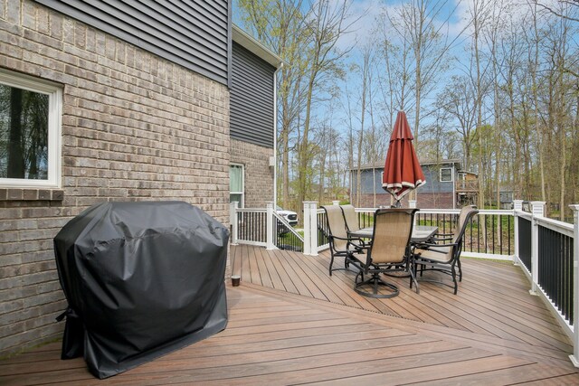 deck with a grill and outdoor dining space
