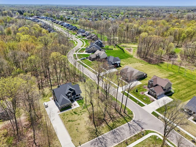 drone / aerial view featuring a residential view and a forest view