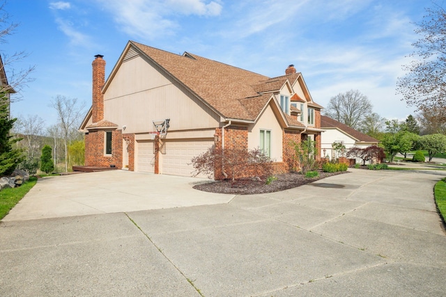 view of side of property featuring brick siding, a garage, driveway, and a chimney