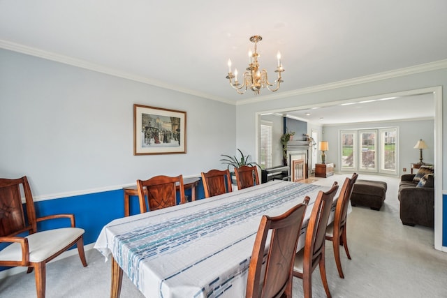 dining area featuring a fireplace, ornamental molding, light carpet, and a notable chandelier