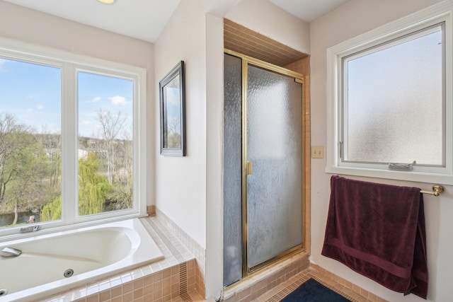 full bathroom featuring a tub with jets, a healthy amount of sunlight, and a shower stall