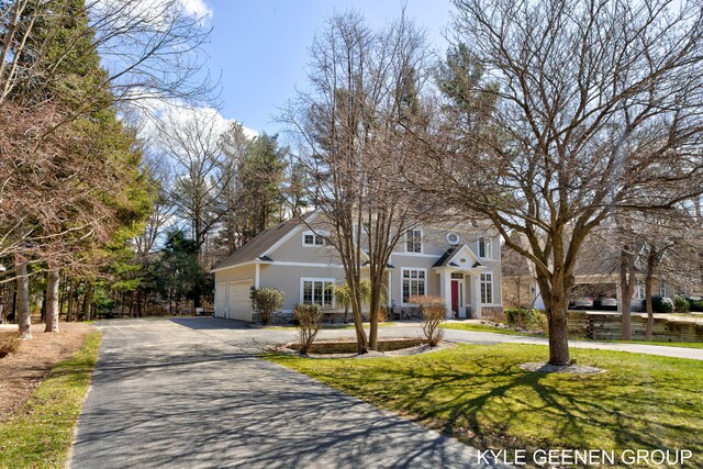 view of front of property with a garage, a front lawn, and aphalt driveway