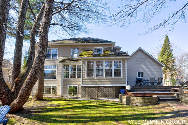 rear view of house featuring a lawn and a wooden deck