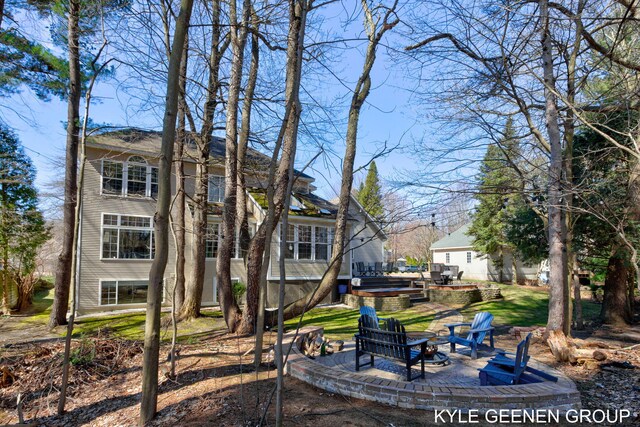 view of yard featuring a patio, a jacuzzi, and an outdoor fire pit