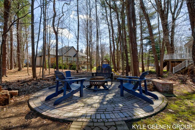 view of patio / terrace with a wooden deck, a fire pit, and stairway