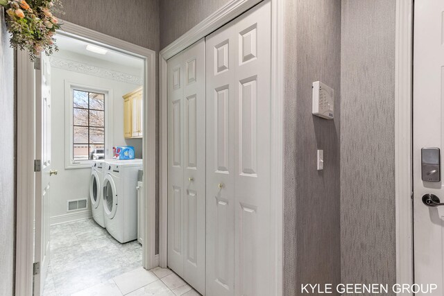 laundry room with baseboards, washing machine and dryer, cabinet space, and visible vents