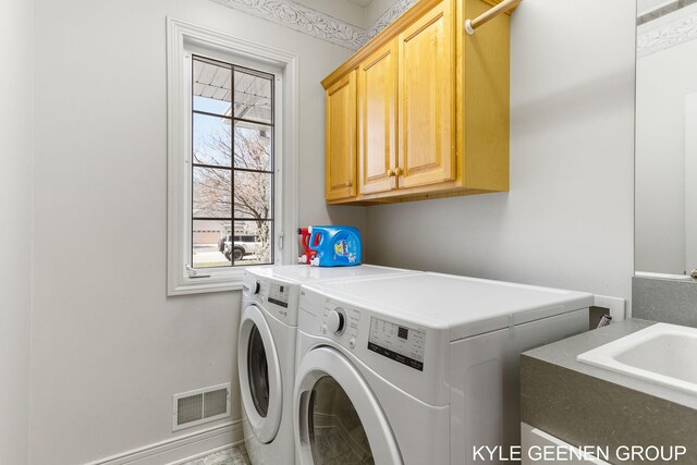 laundry room featuring cabinet space, separate washer and dryer, visible vents, and a sink