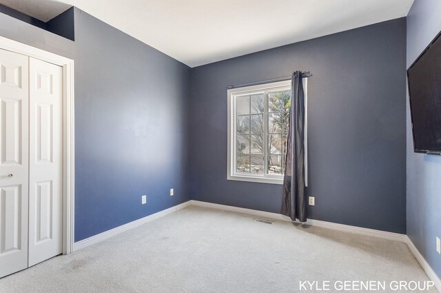 empty room featuring carpet flooring, baseboards, and visible vents