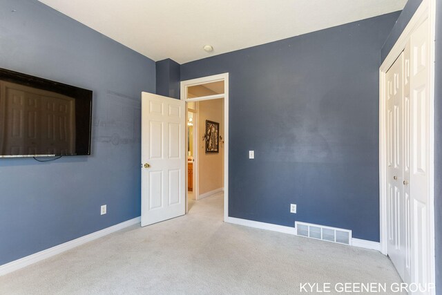unfurnished bedroom with carpet floors, baseboards, a closet, and visible vents