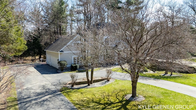 view of front of home with a garage, a front yard, and aphalt driveway