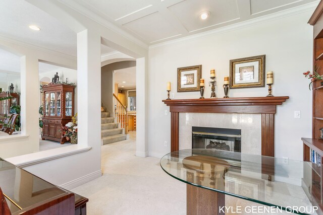 carpeted living area featuring arched walkways, ornamental molding, stairway, and a fireplace