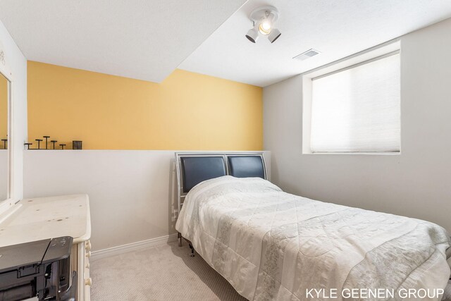 bedroom with baseboards, visible vents, and carpet