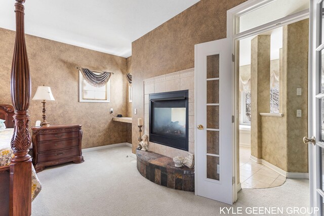 carpeted living room with baseboards, a tiled fireplace, and tile patterned flooring
