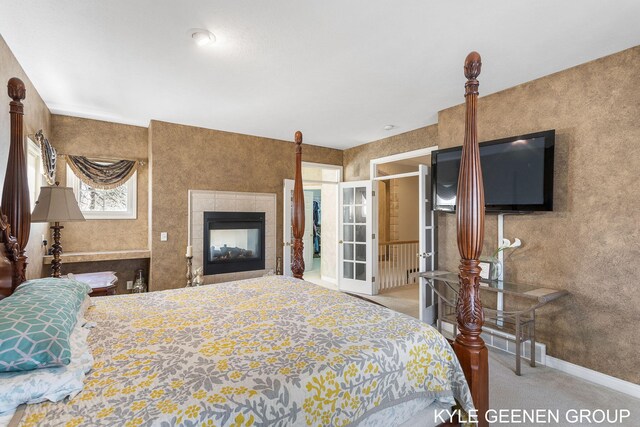 bedroom with a fireplace, baseboards, carpet, and french doors