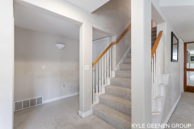 stairway featuring baseboards, visible vents, and carpet