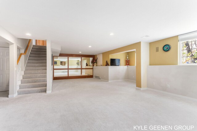 unfurnished living room with stairway, baseboards, carpet flooring, and recessed lighting