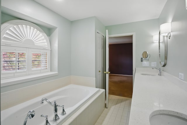 bathroom featuring tile patterned floors, a garden tub, and vanity