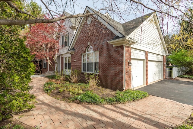 view of property exterior with brick siding and aphalt driveway