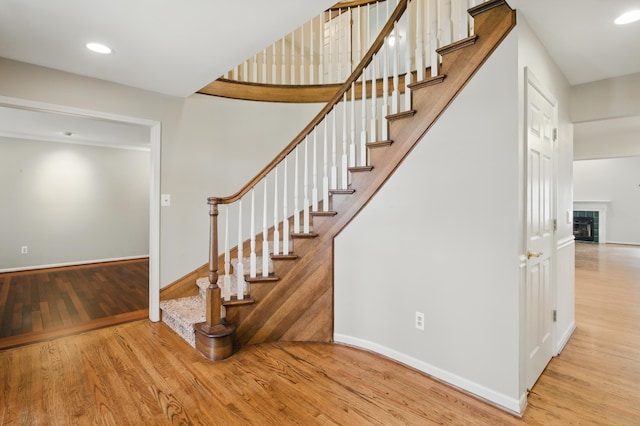 stairs with baseboards, recessed lighting, and wood finished floors
