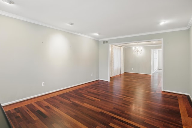 empty room with visible vents, crown molding, wood finished floors, and a chandelier