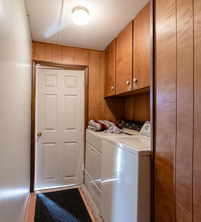 laundry room with separate washer and dryer and cabinet space