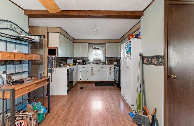 kitchen featuring stainless steel range with gas cooktop, a sink, wood finished floors, and beam ceiling