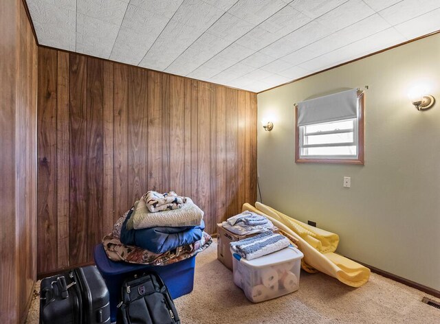 misc room with visible vents, carpet flooring, and wood walls