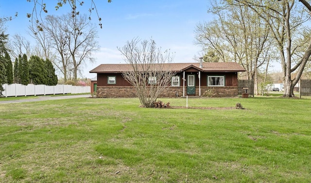 single story home featuring fence, a front yard, and brick siding