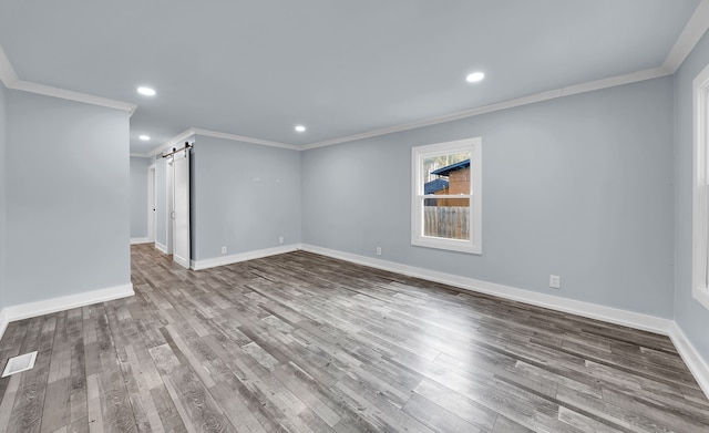 basement featuring crown molding, visible vents, a barn door, and recessed lighting
