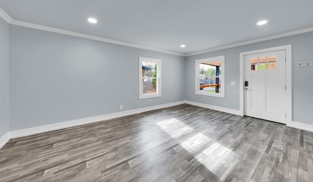 entrance foyer featuring wood finished floors, baseboards, and ornamental molding