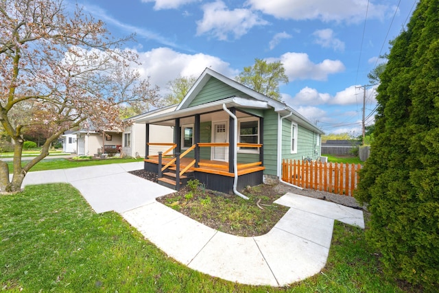 view of front of property featuring a porch, a front lawn, and fence