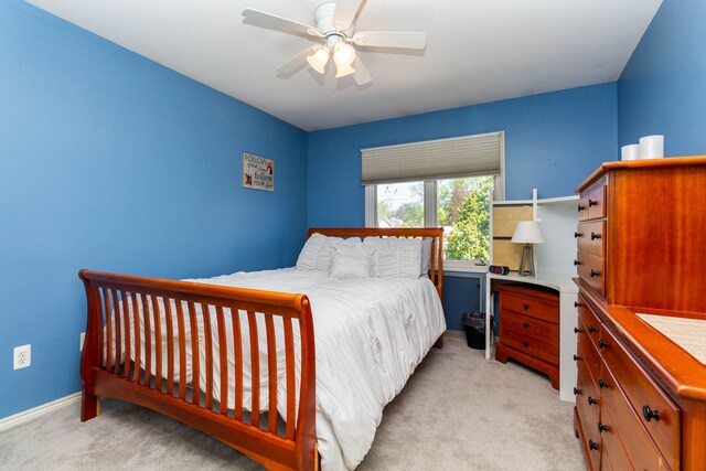 bedroom with baseboards, a ceiling fan, and light colored carpet