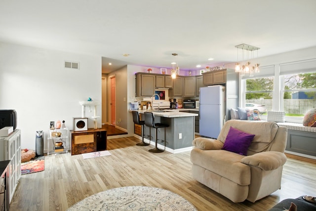 living room featuring visible vents, recessed lighting, light wood-style floors, and a toaster