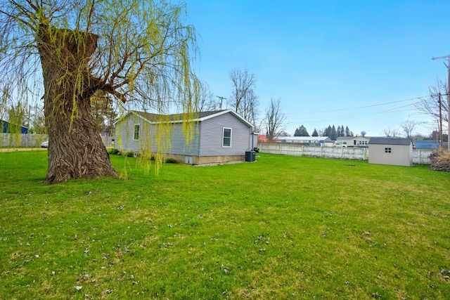view of yard with an outdoor structure, fence, a shed, and cooling unit