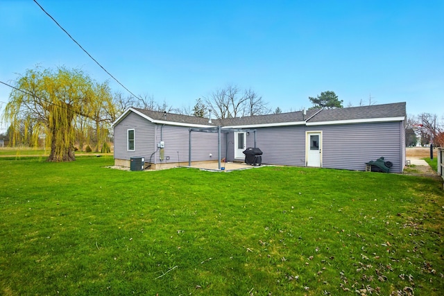 back of house featuring a lawn, a patio area, and central air condition unit