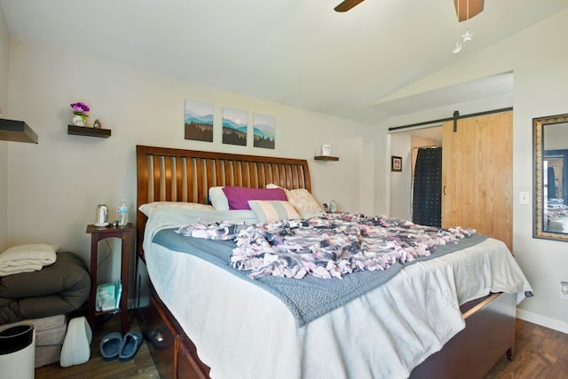 bedroom with ceiling fan, a barn door, wood finished floors, baseboards, and lofted ceiling