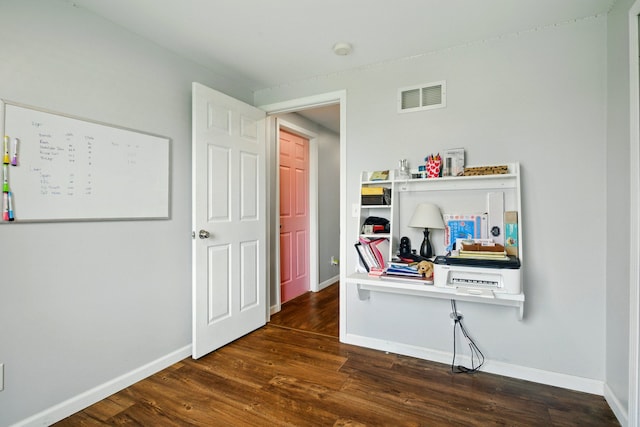 interior space with baseboards, visible vents, and dark wood-type flooring