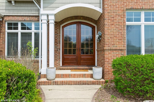doorway to property featuring brick siding and french doors