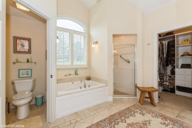 bathroom with a walk in closet, a bath, toilet, and a shower stall