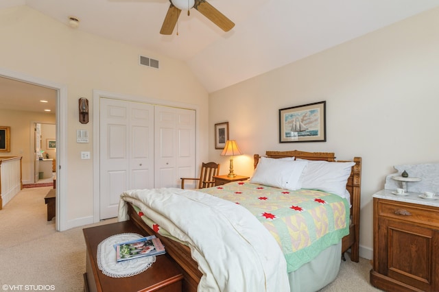 bedroom featuring a closet, visible vents, lofted ceiling, baseboards, and light colored carpet