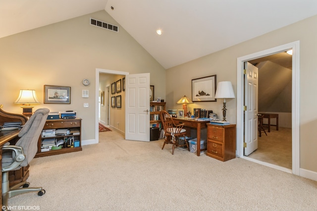 office space featuring visible vents, baseboards, high vaulted ceiling, and light carpet