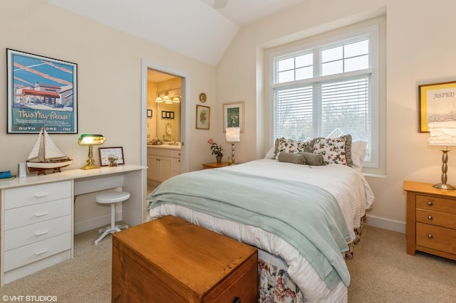 carpeted bedroom with baseboards, ensuite bath, and vaulted ceiling