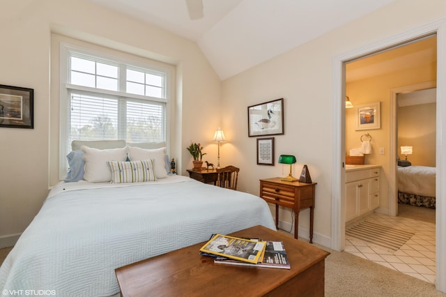 bedroom with ceiling fan, light colored carpet, baseboards, ensuite bathroom, and lofted ceiling