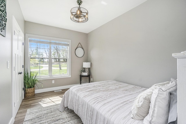 1709 Westview Dr, Allegan, MI 49010 - bedroom featuring baseboards, wood finished floors, a chandelier, and visible vents