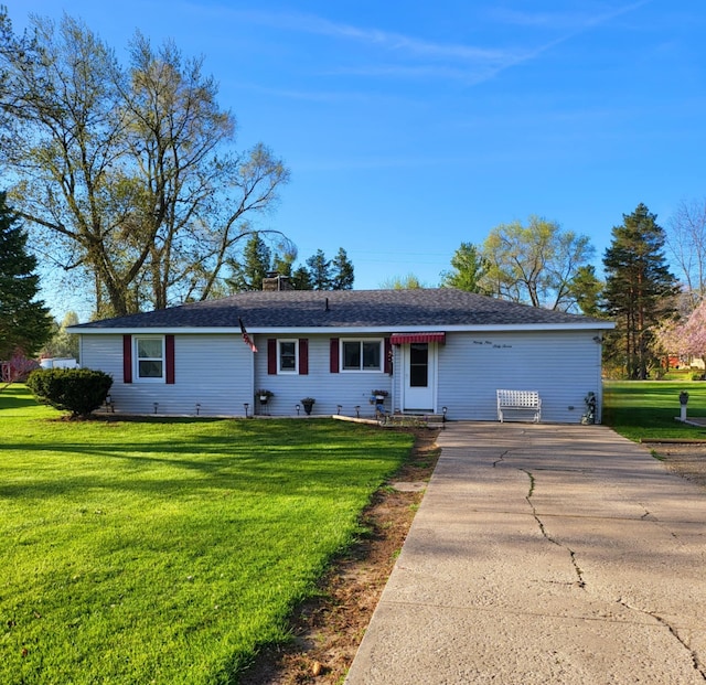 ranch-style home featuring a front lawn, a chimney, and concrete driveway