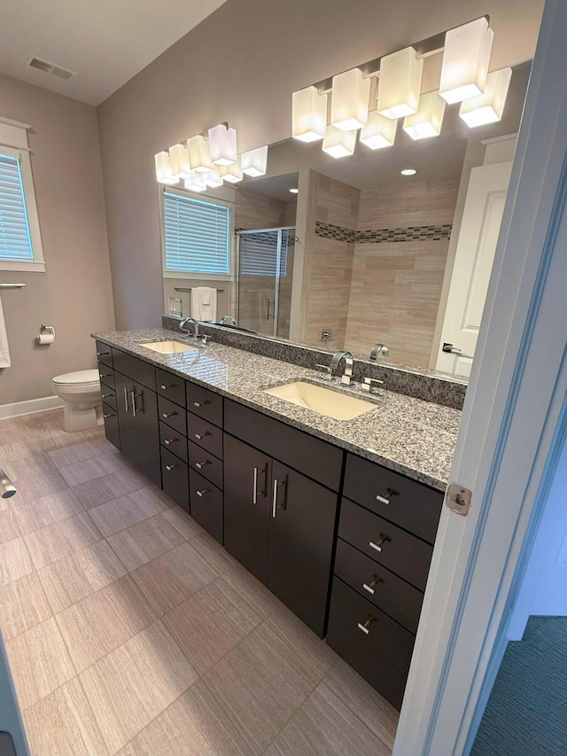 full bathroom featuring baseboards, visible vents, a shower stall, and a sink