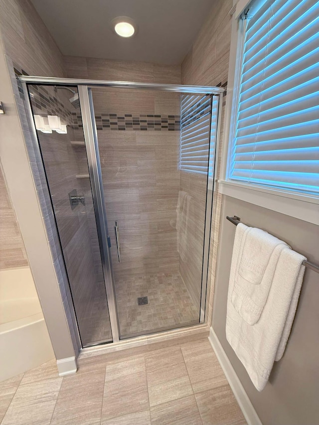 full bathroom featuring a bath and a stall shower
