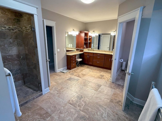 bathroom featuring vanity, baseboards, and a shower stall