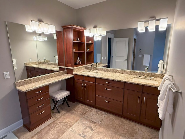 bathroom featuring double vanity, baseboards, and a sink