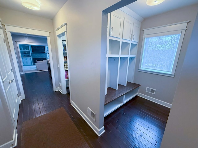 mudroom featuring visible vents, baseboards, and dark wood-style floors